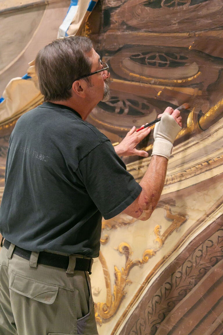 Michael Denering 2023 (Top), Joe Francuz (Bottom Lt.), and student Isabella Hollis preserve The Law and the Lady (1951) backdrop at the Texas Performing Arts Fabrication Studios. (Bottom Rt.)