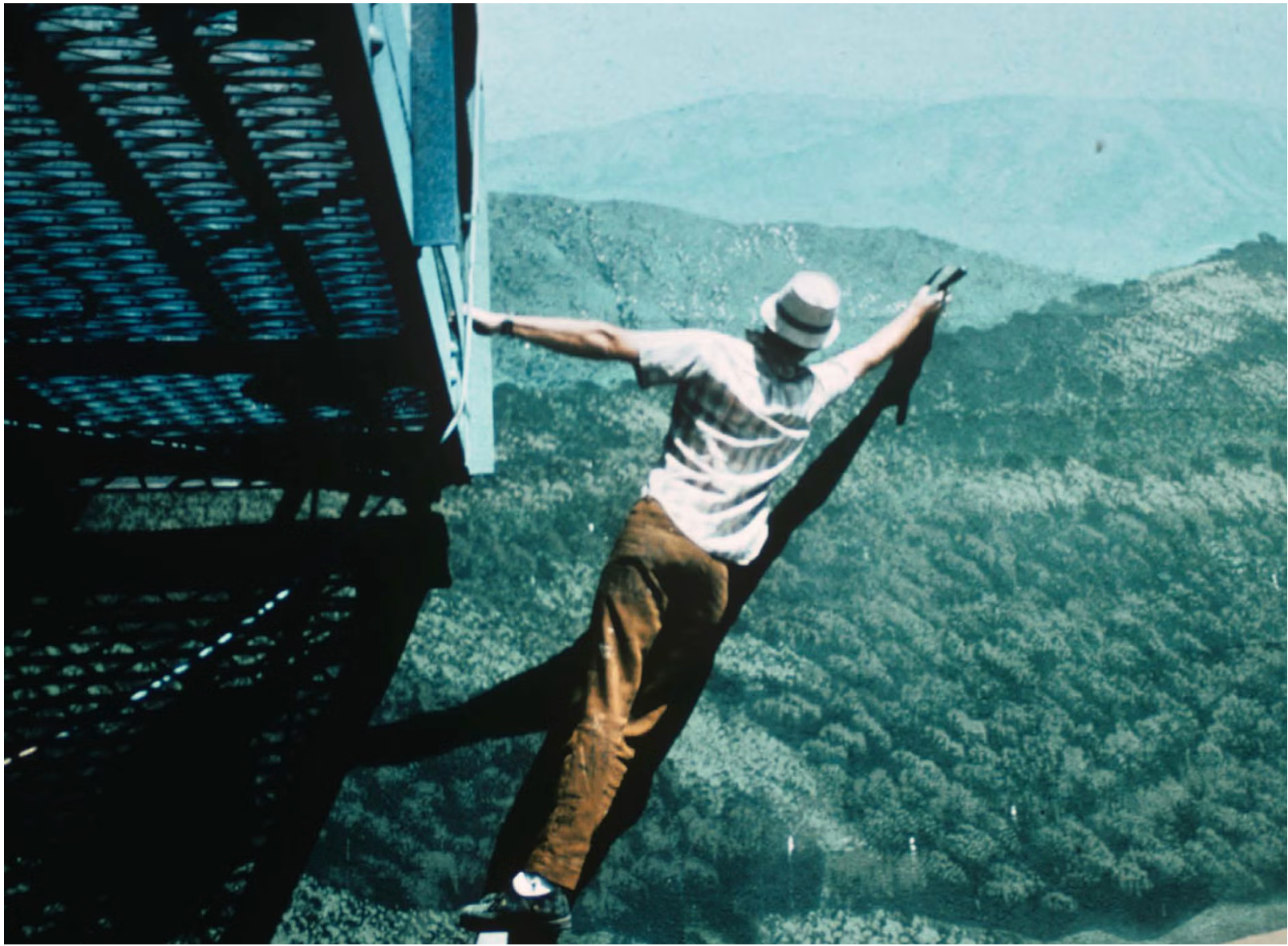 Photo of Bill Anderson as he reaches out on scaffolding to paint on the 20th Century Fox tank stage for <i>Tora Tora Tora</i> (1970)